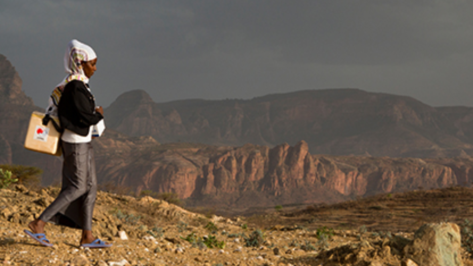 A woman walking with mountains in the background