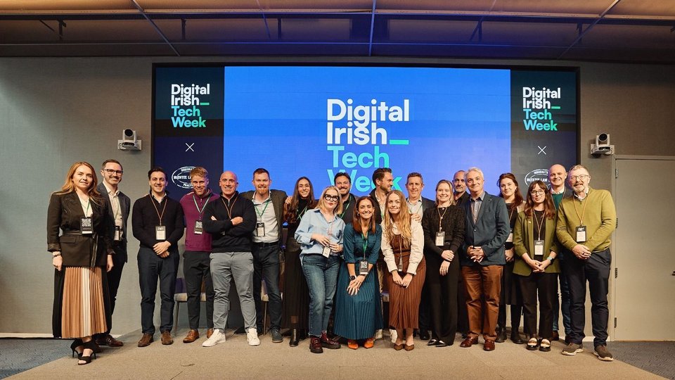 A group of people stood in front of s screen reading 'Digital Irish Tech Week