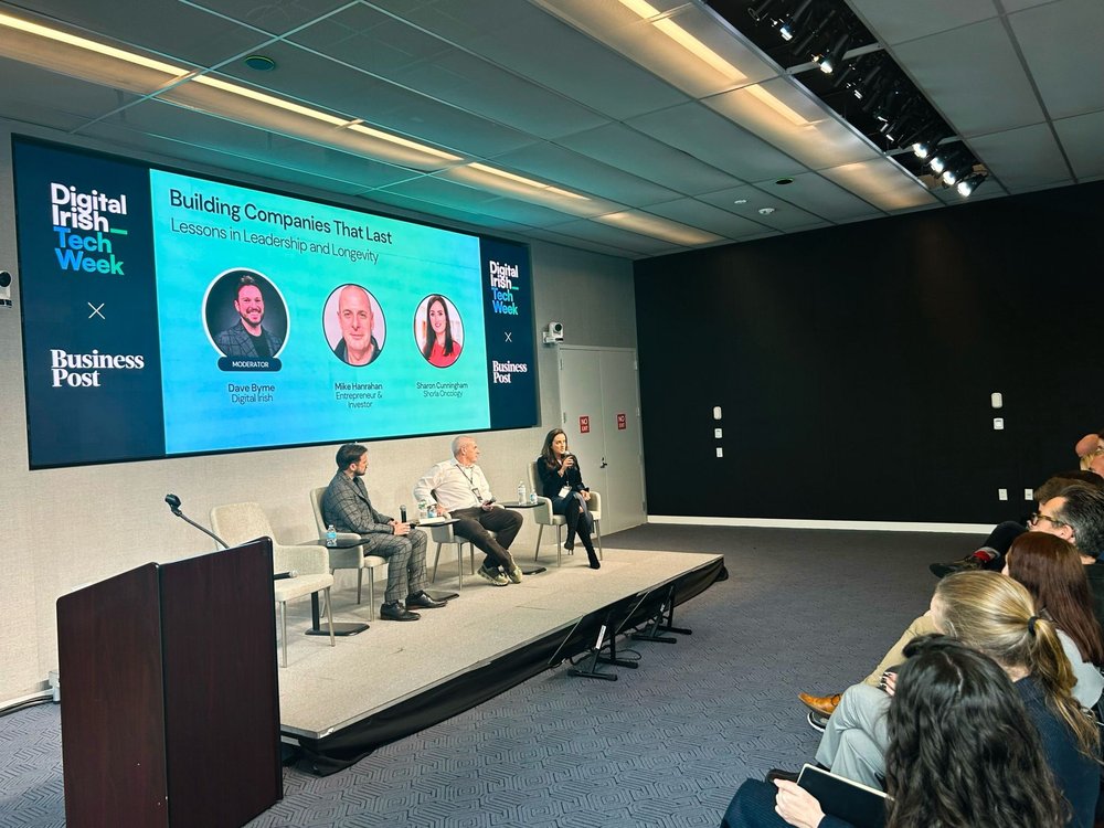 Speakers at a panel with an audience watching them