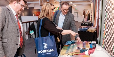 People talking beside tweed garments