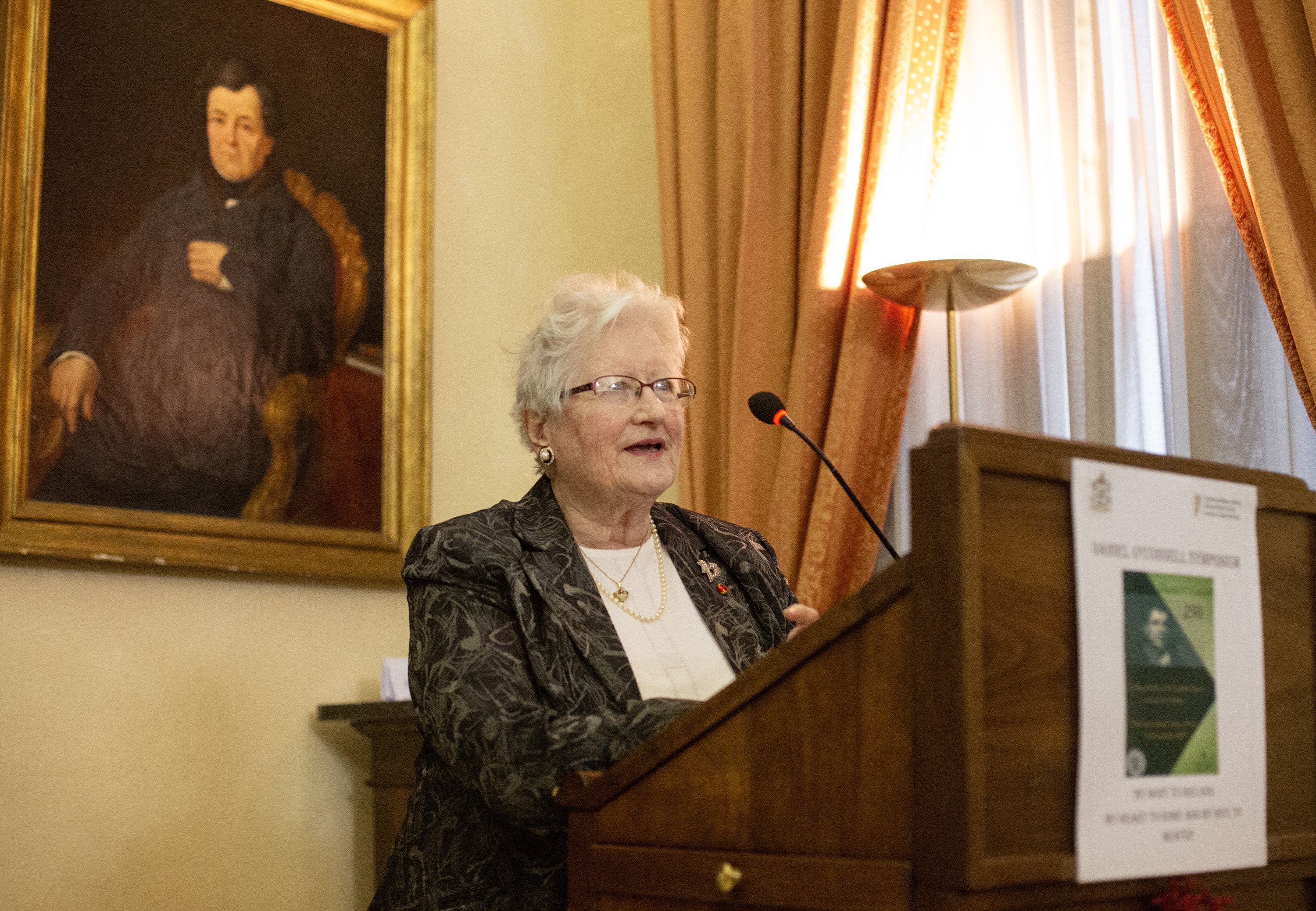 Woman speaking at a plinth