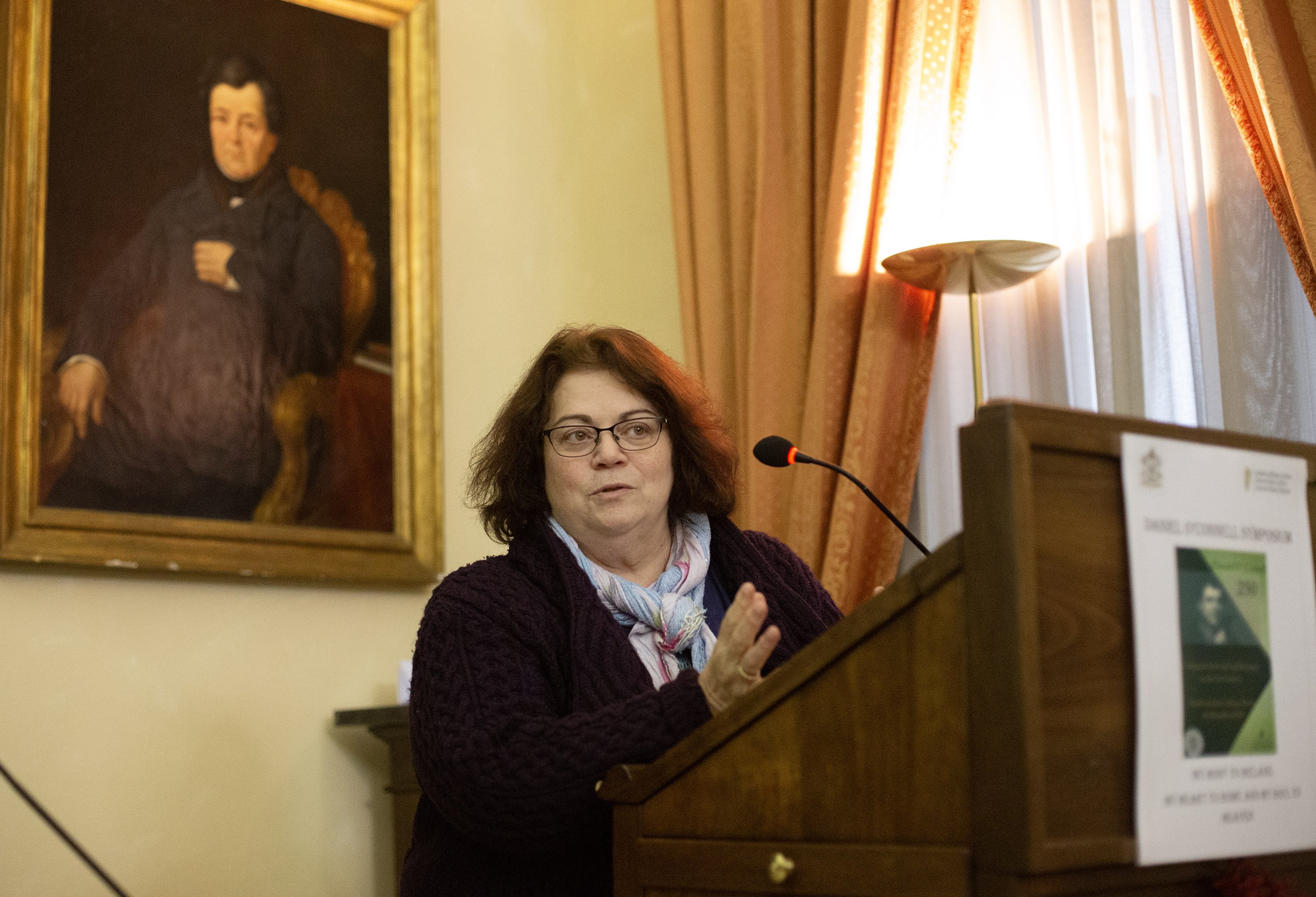 Woman speaking at a plinth