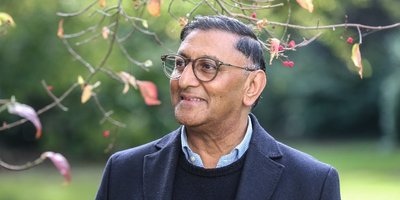 Man looking to the left with trees and foliage in the background