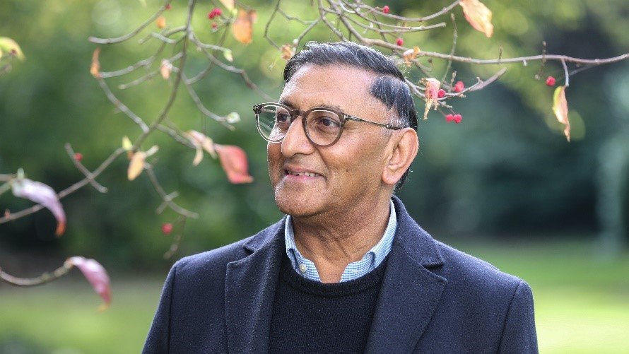 Man looking to the left with trees and foliage in the background