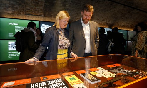 Two people looking at exhibits in a glass case.