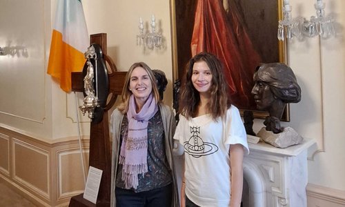 Two women standing in front of an Irish flag.