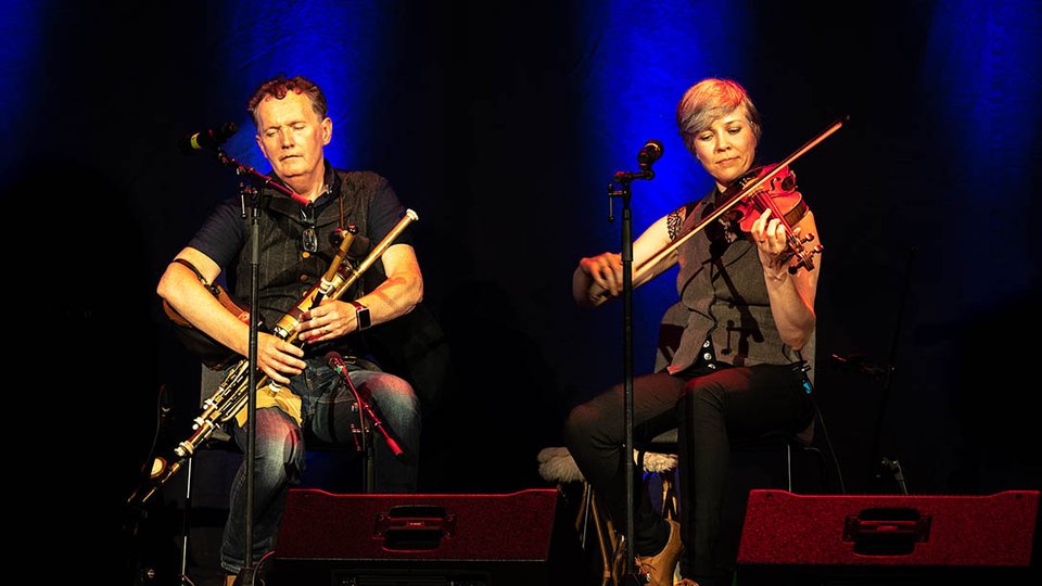 man and woman playing uilleann pipes and fiddle