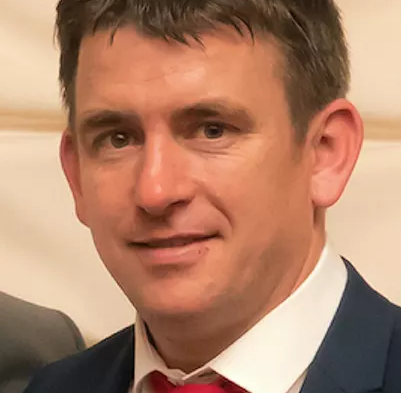 man's face wearing suit and red tie