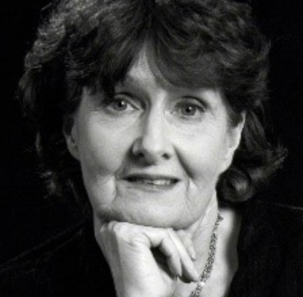 Woman smiling with her fist under her chin