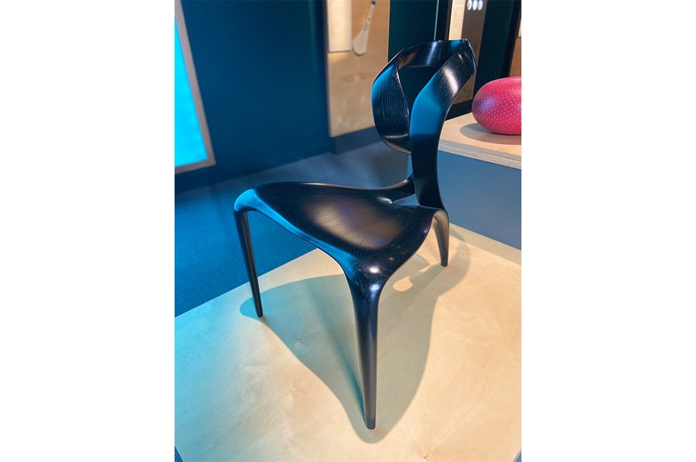 A wooden chair with a fluid design.