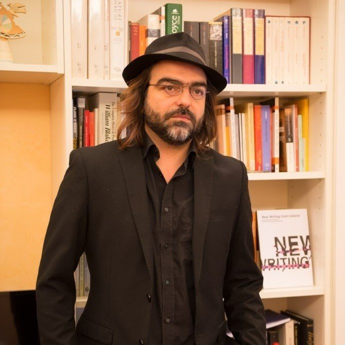 Man standing infront of a bookshelf