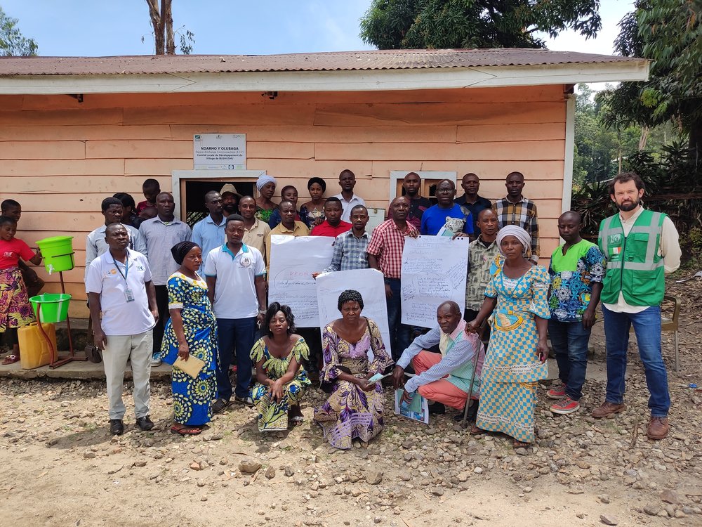 Evin with local people outside a house