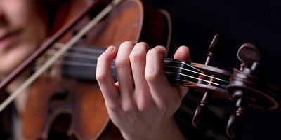 Closeup of a violinist’s hand playing.