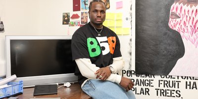 Farouk 858 sitting on his desk wearing a shirt reading 858 in the Irish flag colours