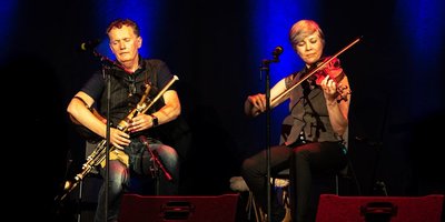 Two musicians playing the uilleann pipes and the fiddle