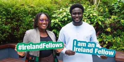 two people holding signs with ireland fellows