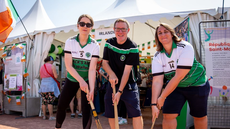 Three people holding hurls at an exhibitor tent