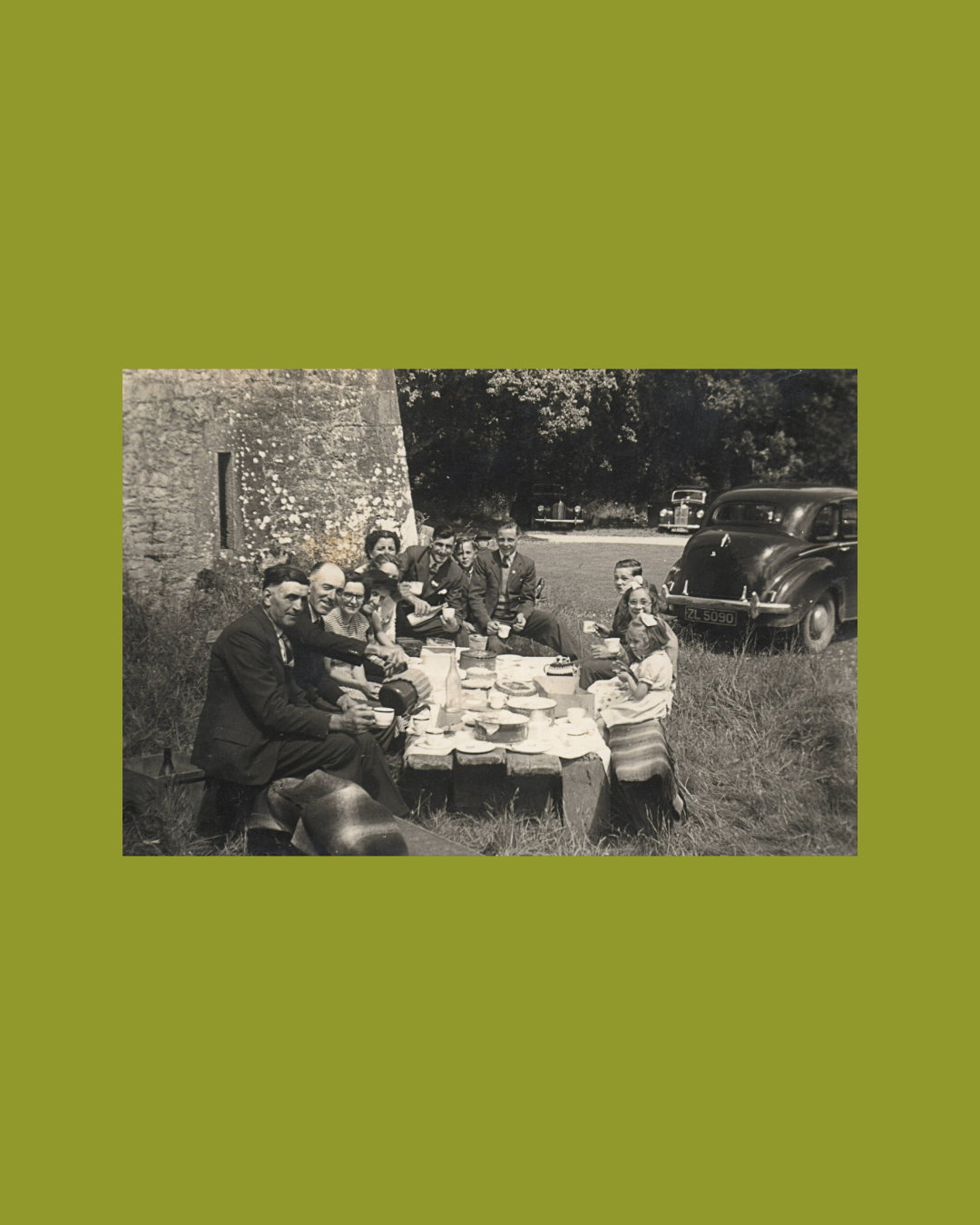 Group of people gathered around a table in a field