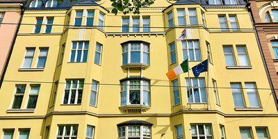 View of the front of the yellow Embassy building.
