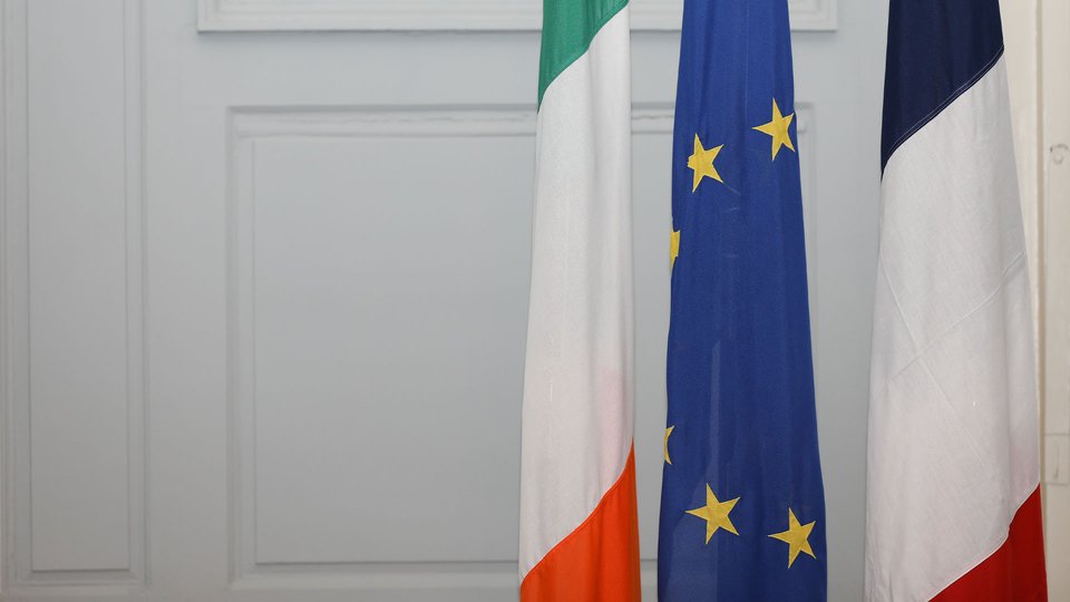 three flags hanging down in front of a white door