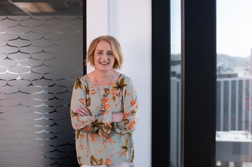 A woman standing with her arms crossed in an office