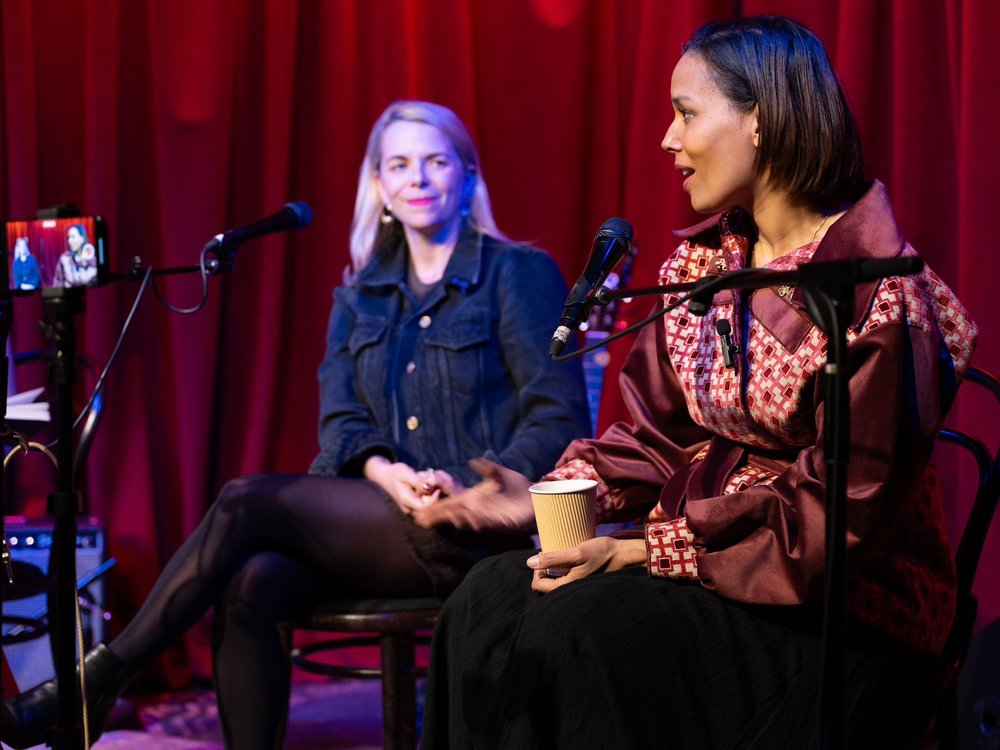 Two women talking on a panel