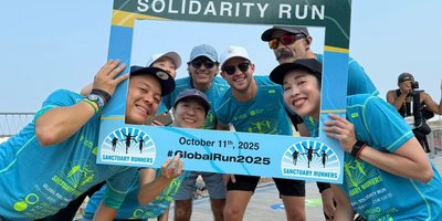 Runners in Osaka holding a Sanctuary Runners sign