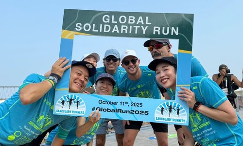 Runners in Osaka holding a Sanctuary Runners sign