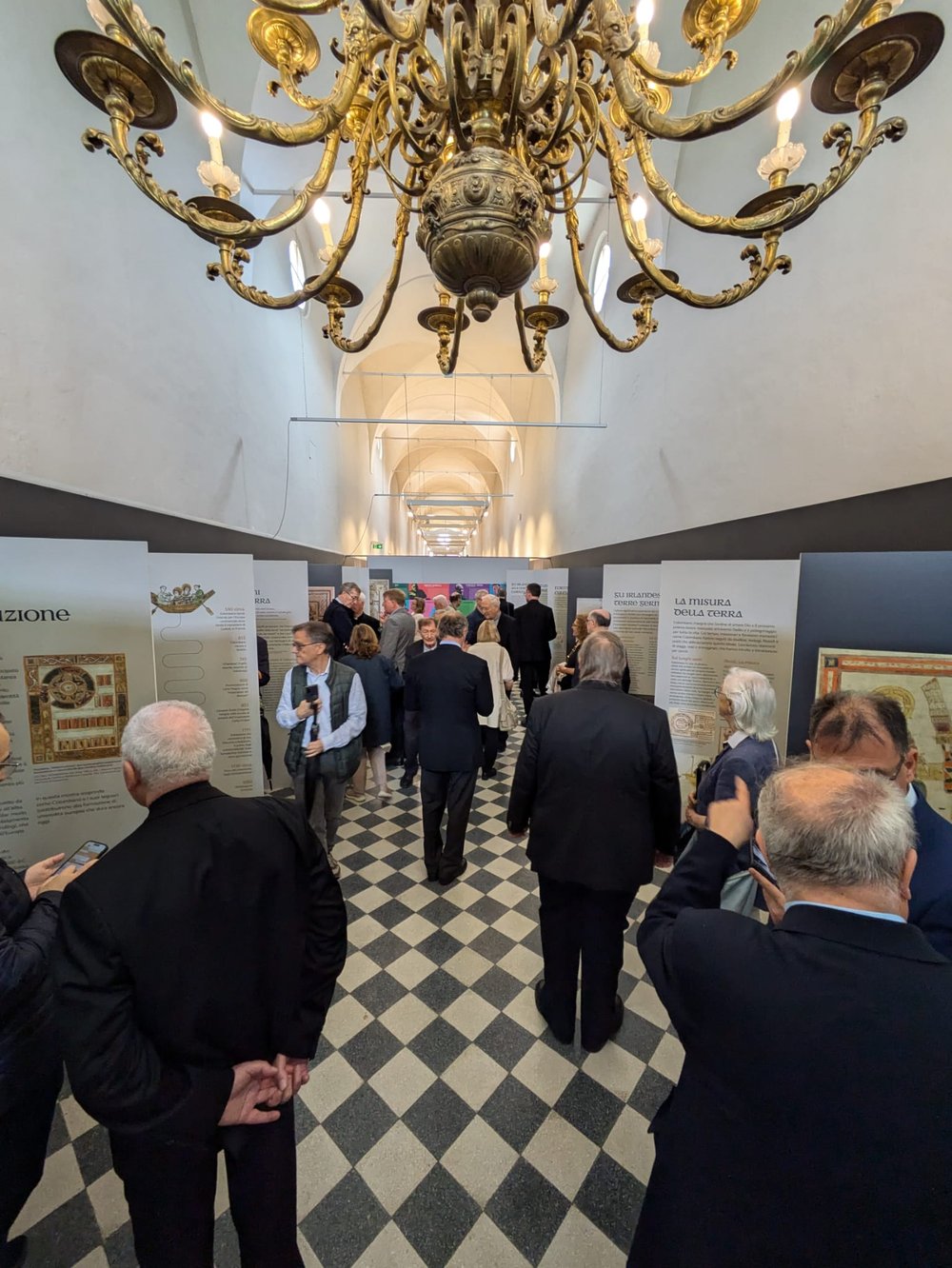 People looking at exhibition panels spaced along a corridor