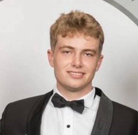 a young man with blonde hair wearing a tuxedo