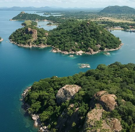 Aerial shot with drone of green mountains and blue water in Monkey Bay, Lake Malawi, Malawi
