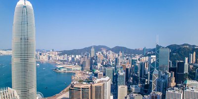 Hong Kong's cityscape skyline with high rise buildings on a sunny day.