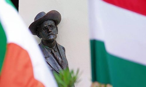 Leopold bloom statue in between Irish and Hungarian flags