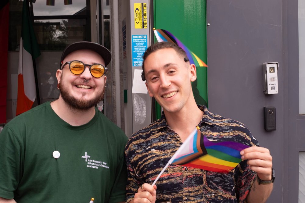 Two people holding pride flags