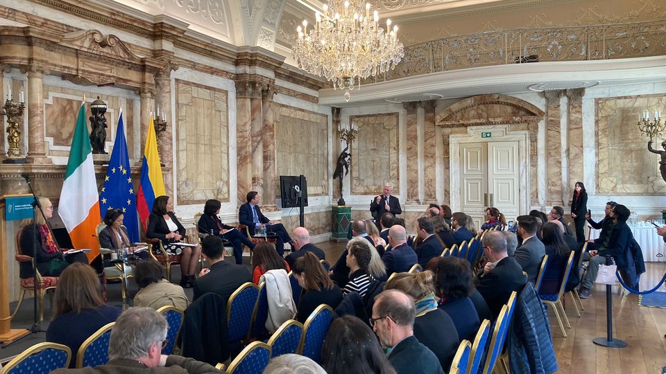 crowd seated at a conference in a old ballroom with chandalier