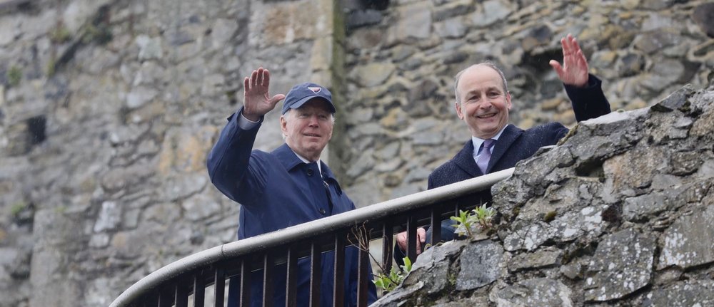 two men on a steps of a castle waving