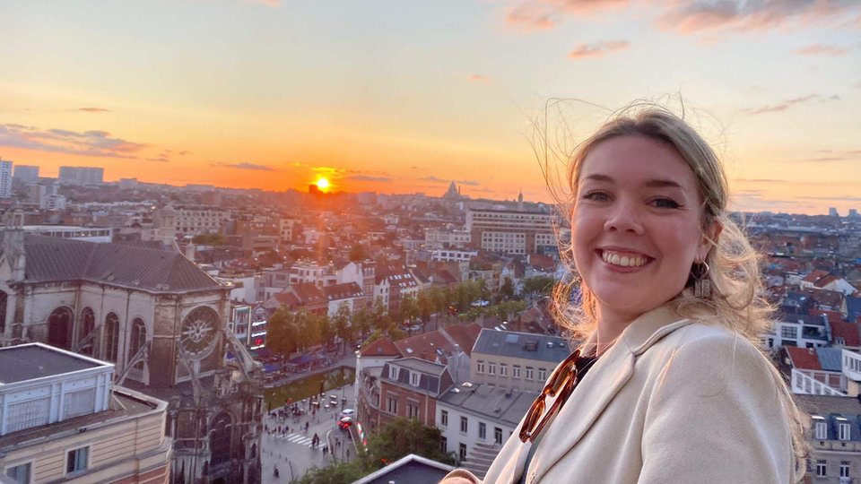 Headshot of Roisin de Bhaldraithe in front of Brussels skyline