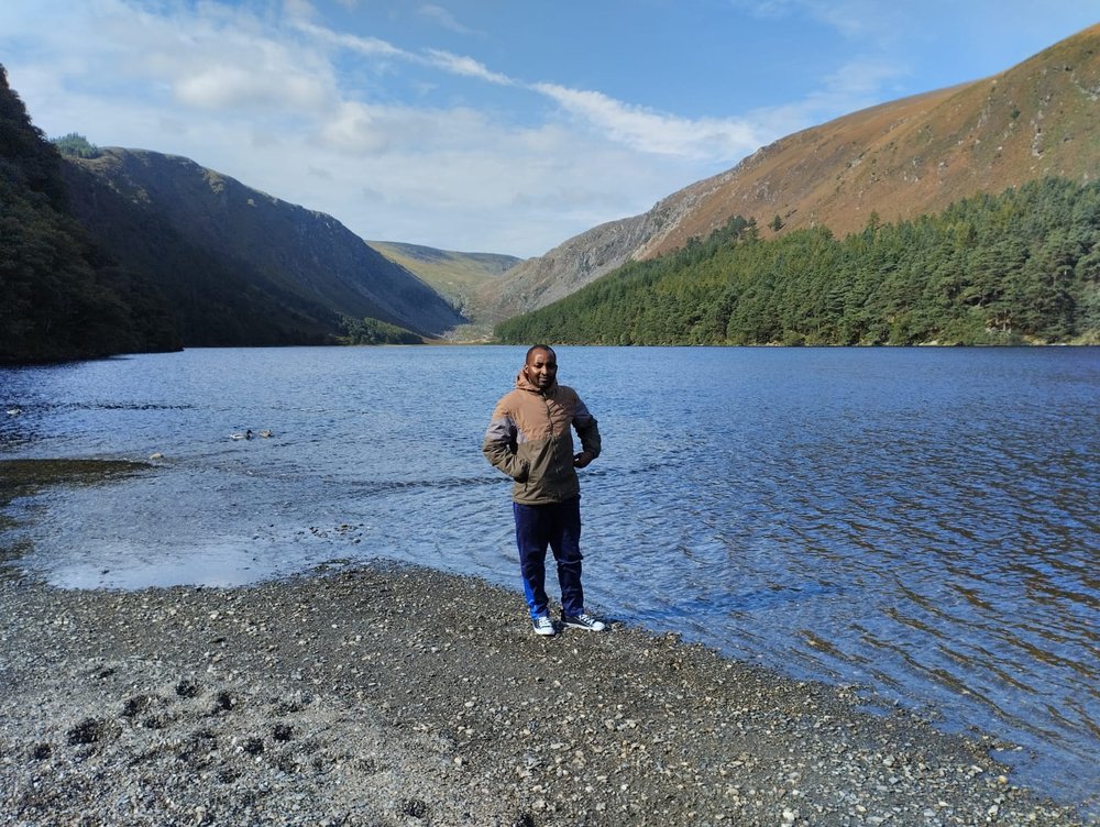 Samuel standing beside a lake