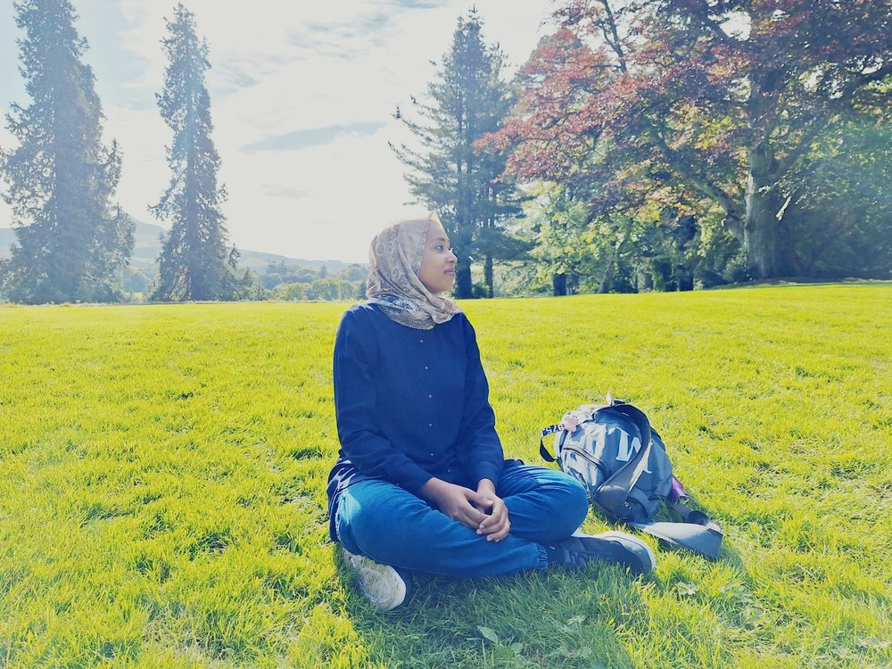 Marwa seating on grass at the university grounds.