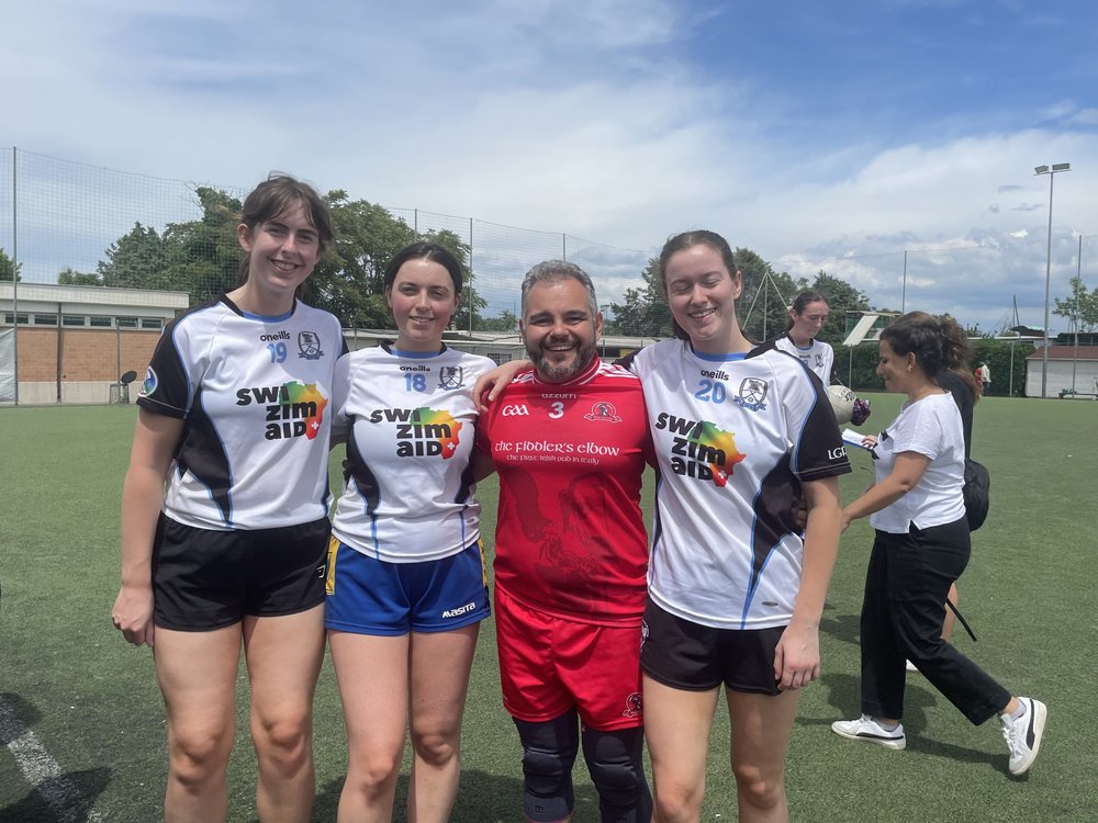 People in GAA gear smiling for a photo on a pitch