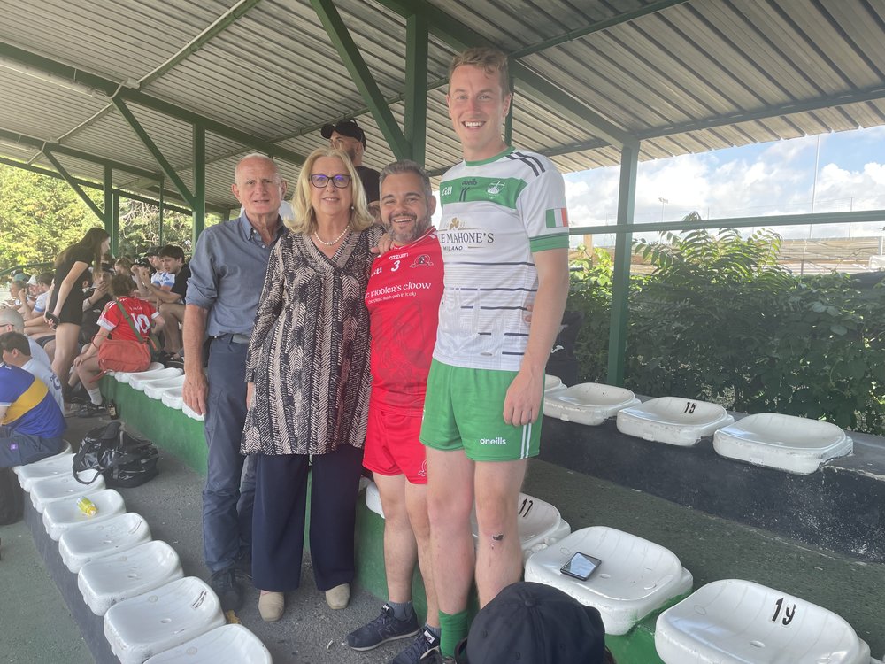 People in GAA gear posing for a photo beside benches