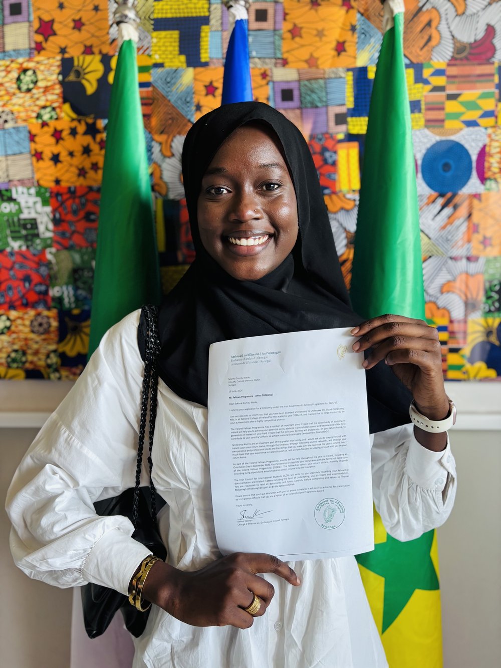Girl smiling as she holds a letter.