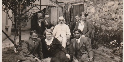 A gathering of Irish and Indian activists in 1932 sitting on a blanket in a garden.