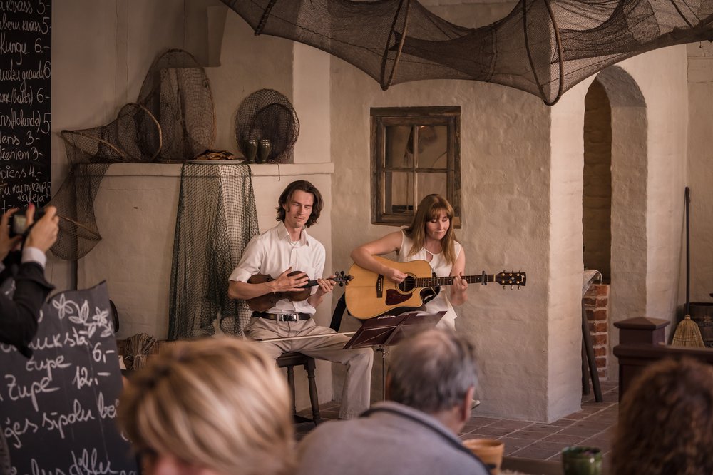A man and a woman playing violin and guitar.