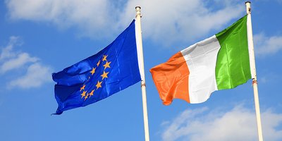 Flags of Ireland and the EU hang from flagpoles.
