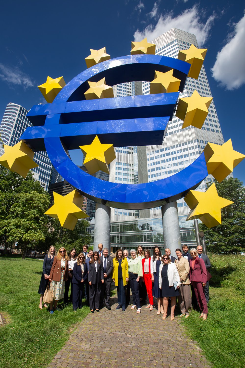 Group photo of delegation of Ambassadors at the Euro sign in Frankfurt.