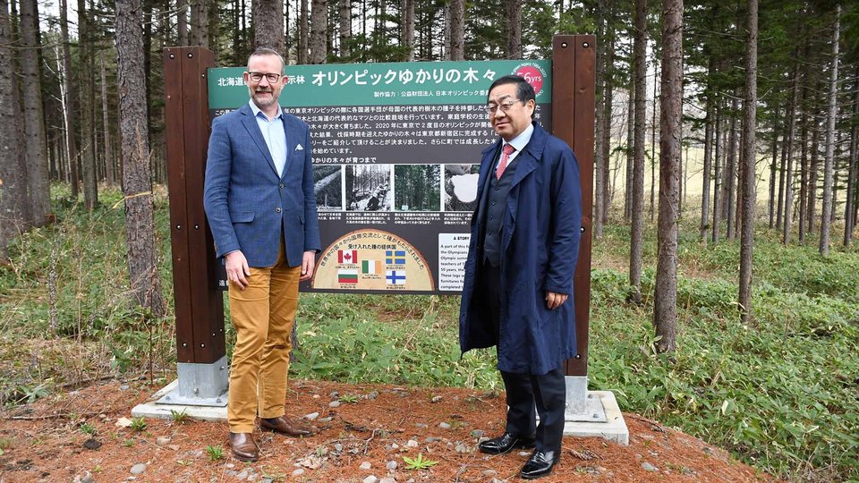 Two men stood in front of a forest in Hokkaido