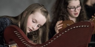 Two young girls playing the harp.