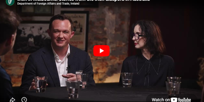 A YouTube thumbnail of two people sitting at a round table talking