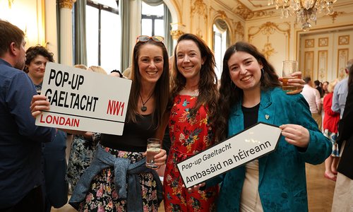 three women holding signs for pop-up Gaeltacht